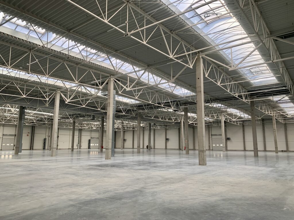 Wnętrze hali z widocznymi świetlikami dachowymi przepuszczającymi naturalne światło