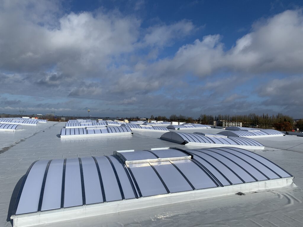 Świetliki zamontowane na dachu hali produkcyjnej z widoczną konstrukcją

