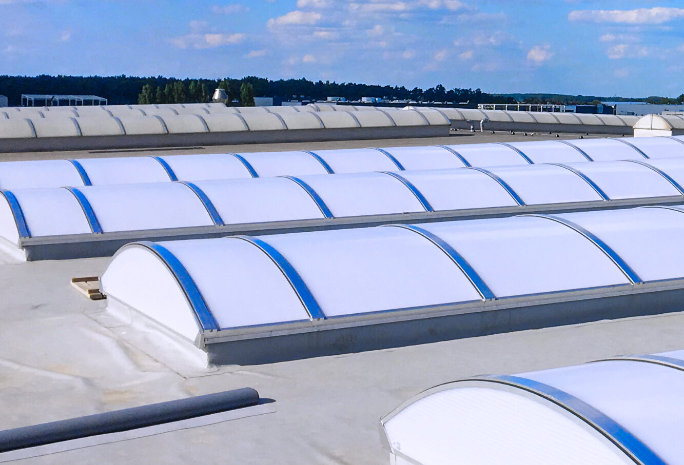 Świetliki dachowe łukowe na hali przemysłowej.